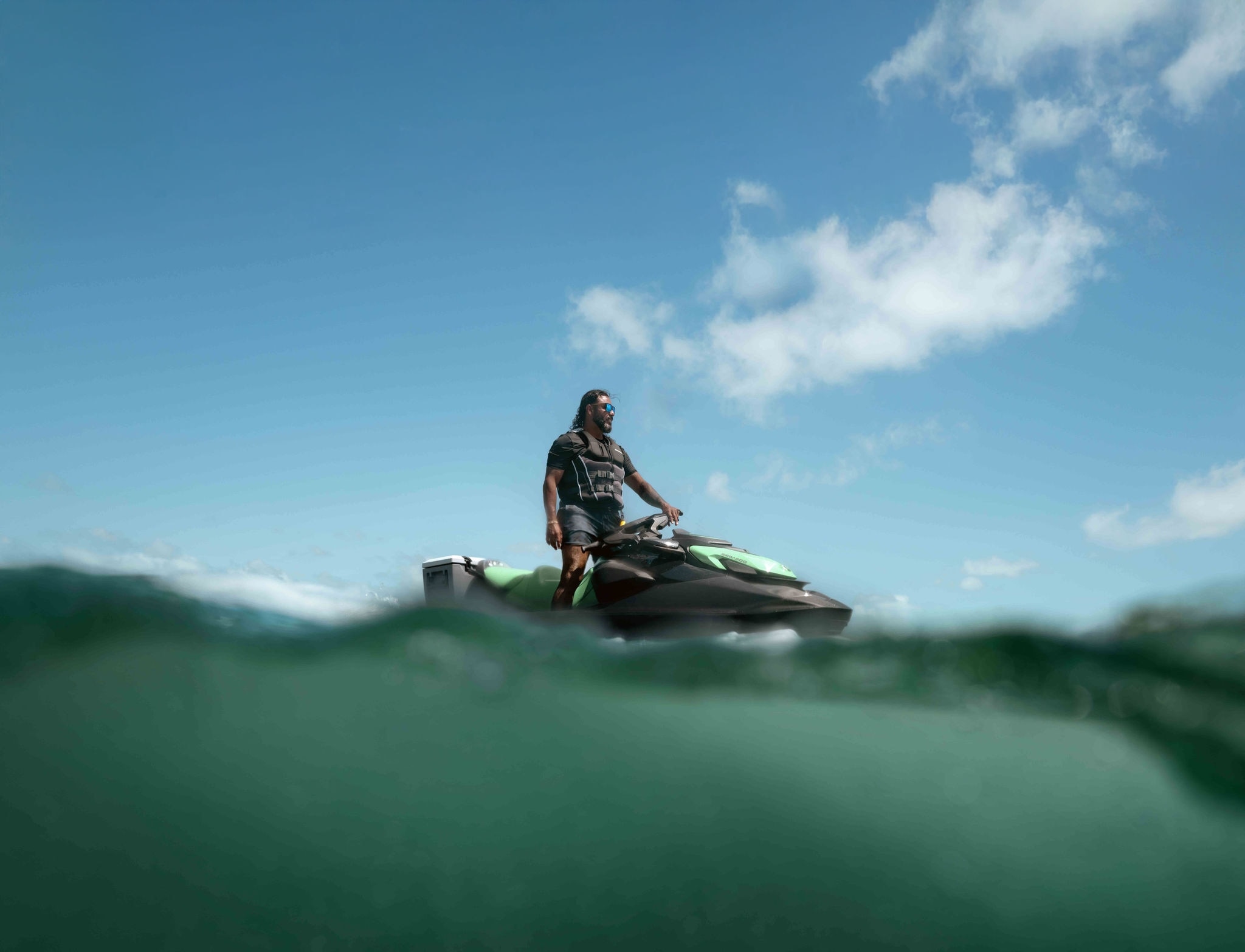 Un hombre de pie sobre su moto acuática Sea-Doo GTI SE 2026.