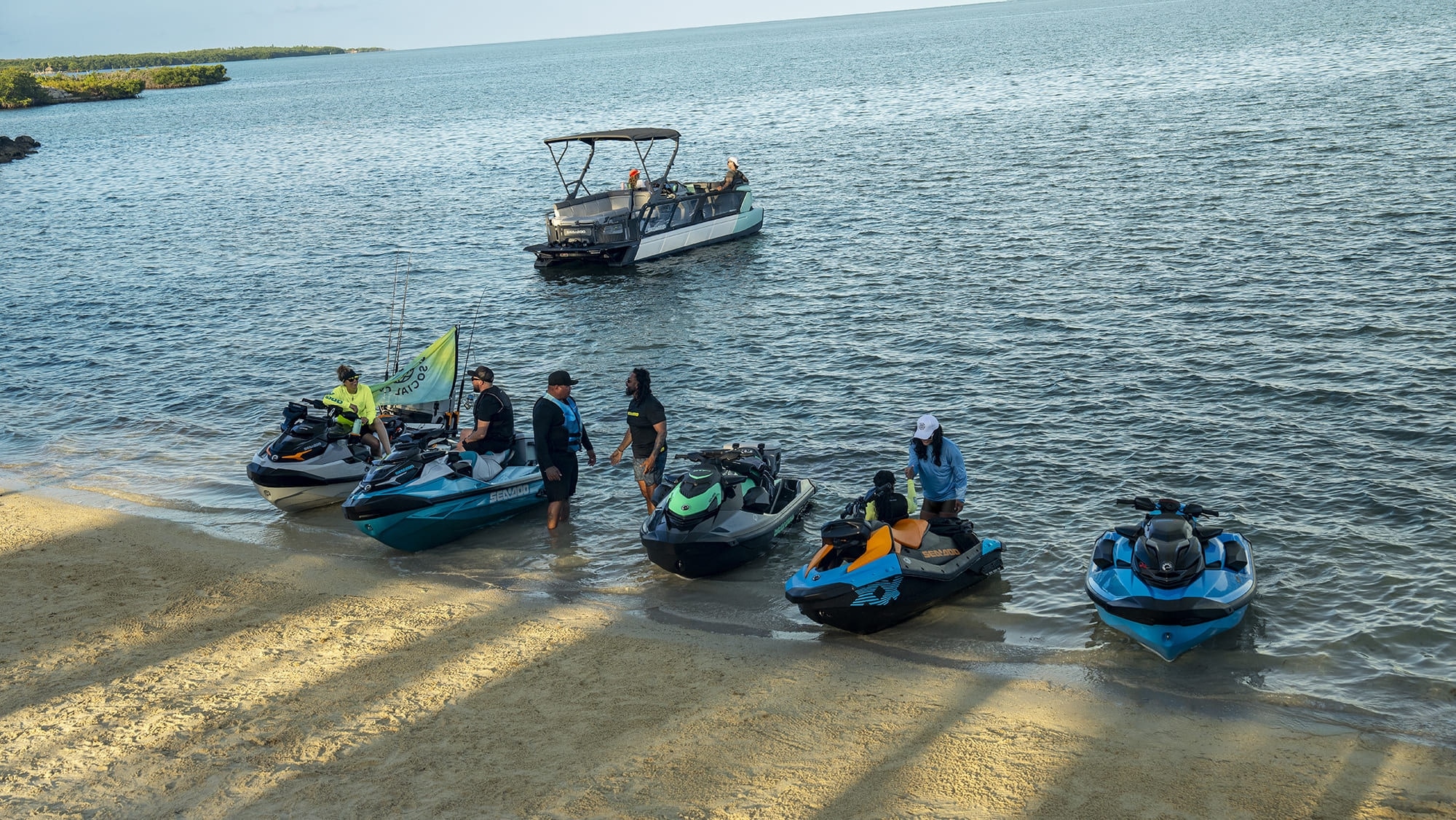 Modelos Sea-Doo atracados na areia com Sea-Doo Switch ao fundo
