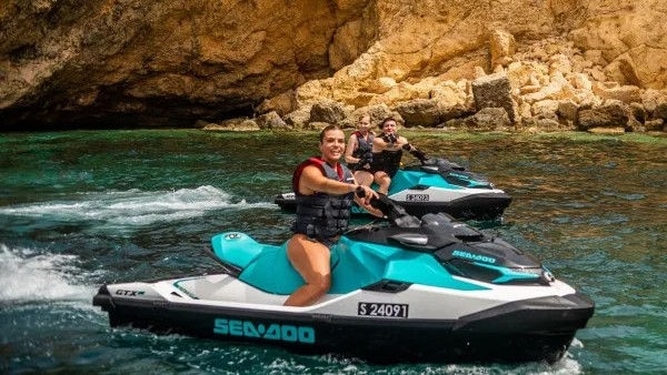 Group of friends riding Sea-Doo personal watercrafts in St Julians in Malta