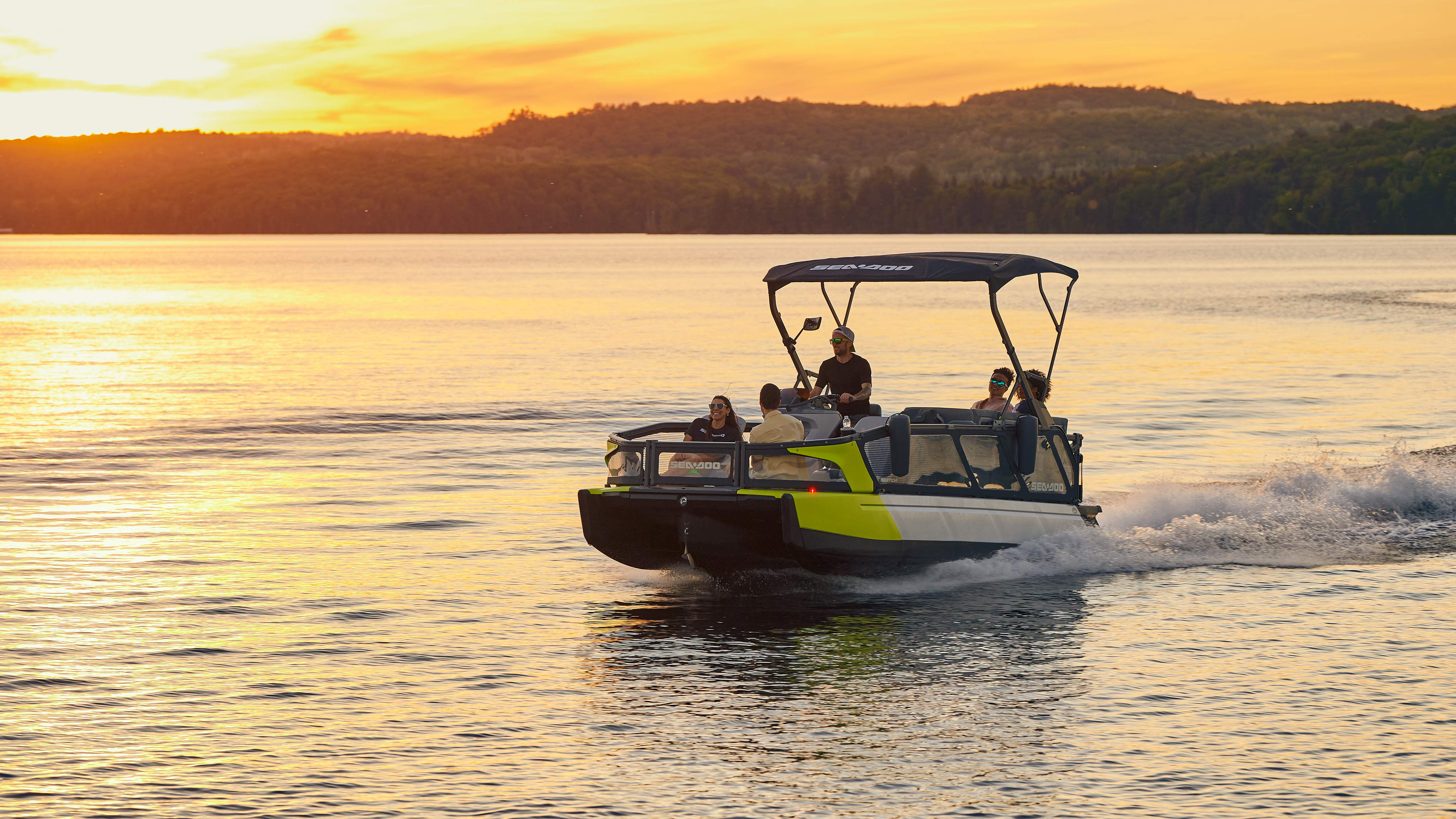 Group of friends riding a Sea-Doo Switch Pontoon at sunset