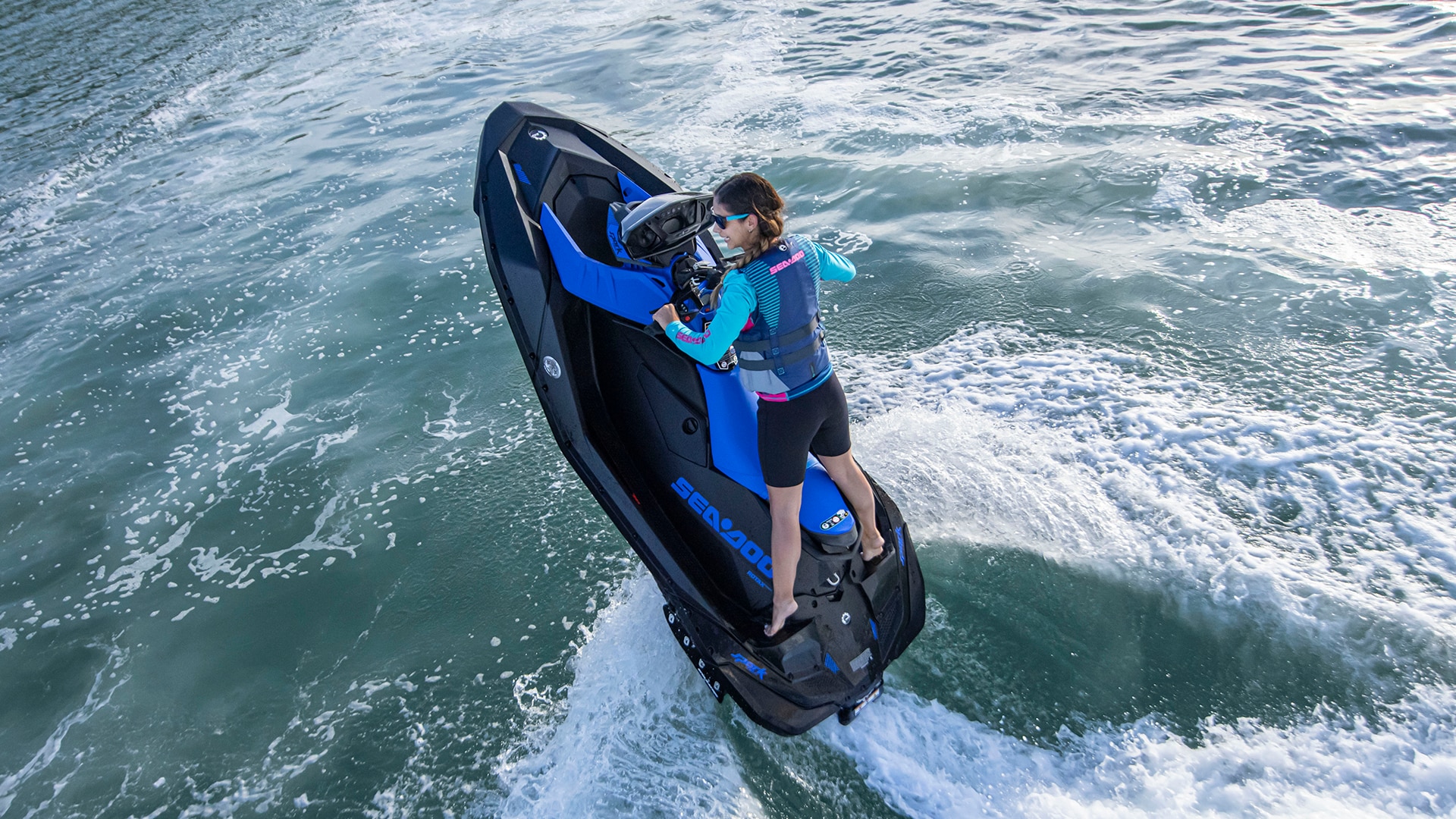 A woman rider pulling off a trick on a Sea-Doo Spark Trixx personal watercraft