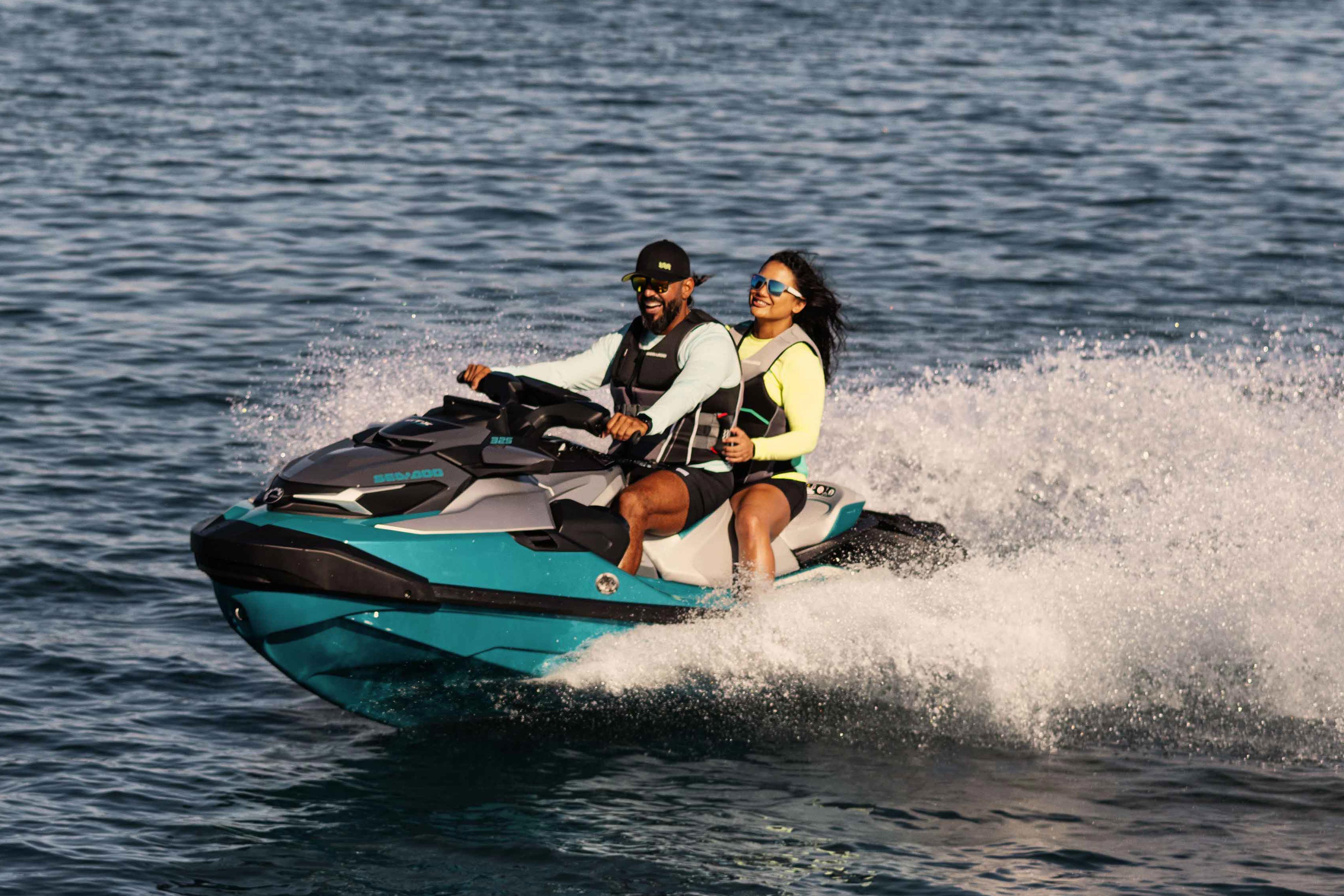 Pareja disfrutando mientras conducen por el mar en una Sea-Doo