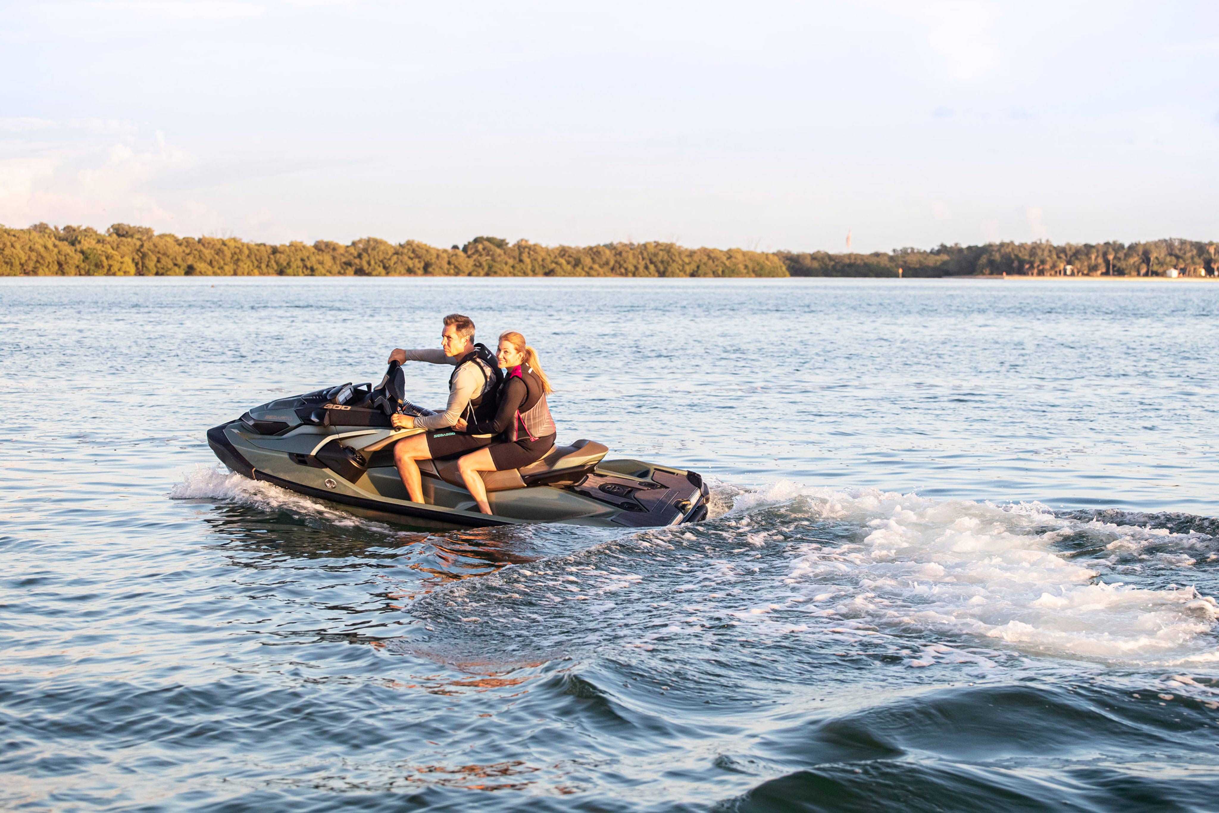 Pareja disfrutando del atardecer sobre su Sea-Doo en el mar 