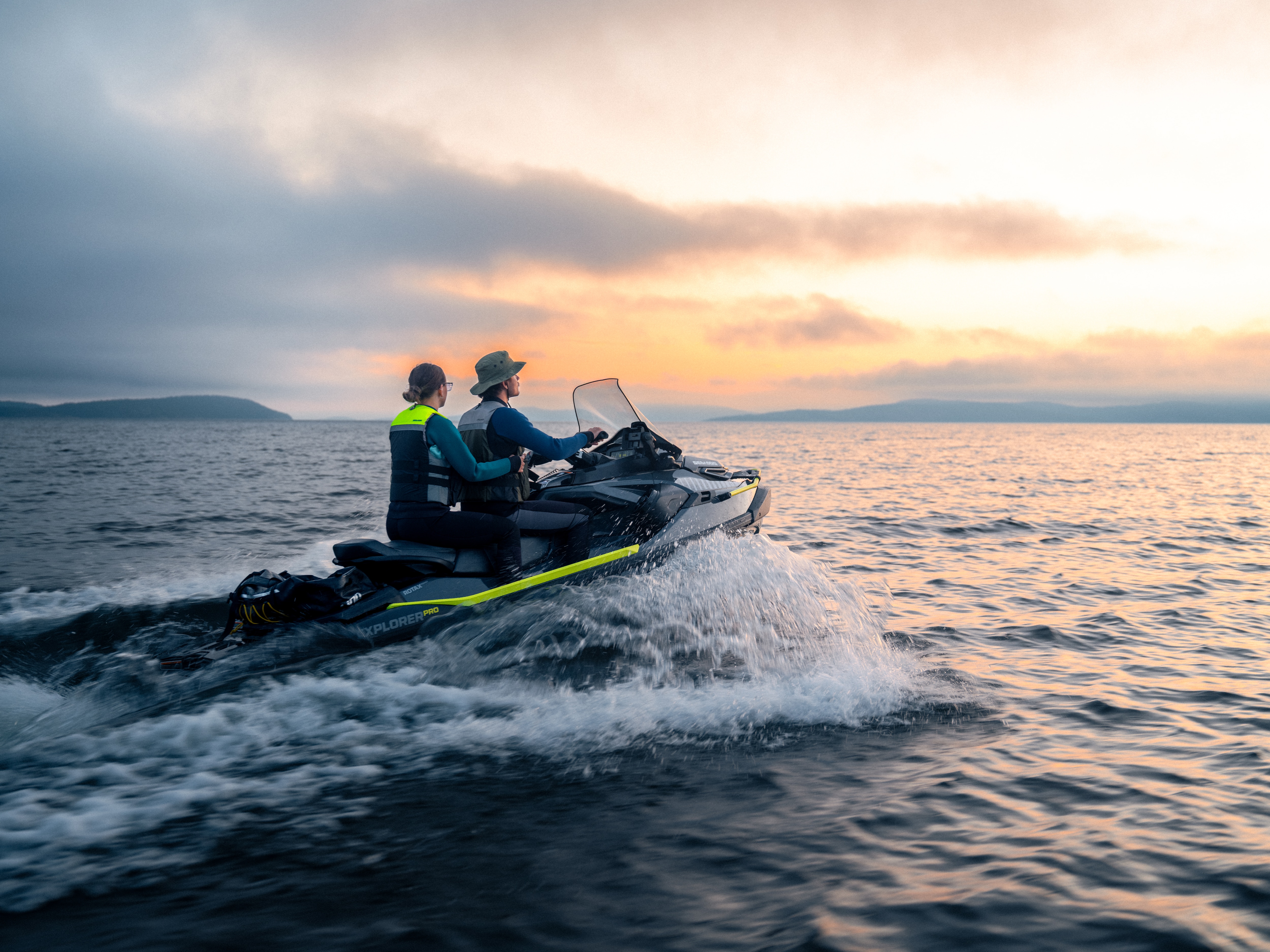 Pareja disfrutando de una moto de agua Sea-Doo Explorer al atardecer