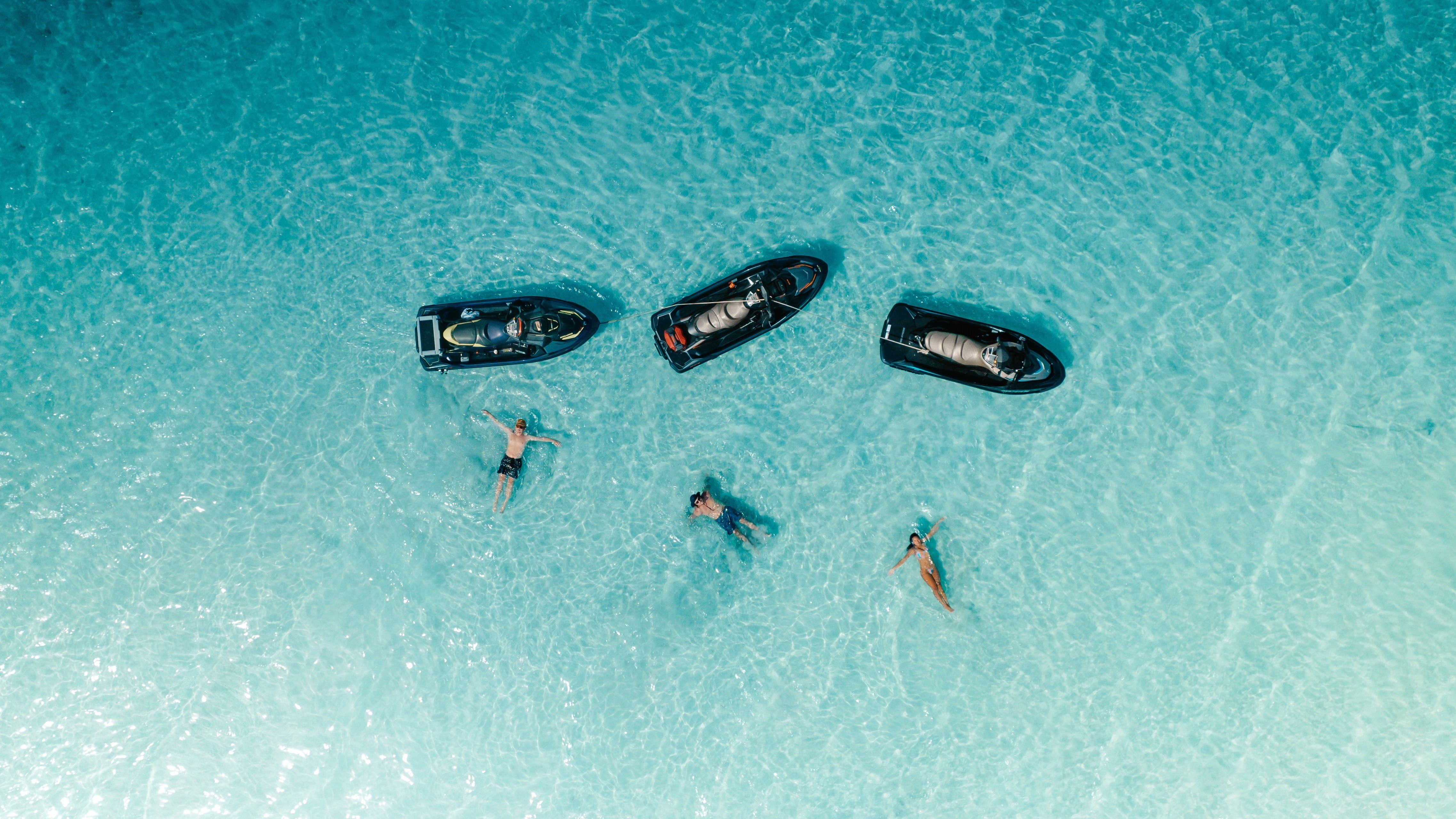 Adventure-seekers swimming next to their Sea-Doo