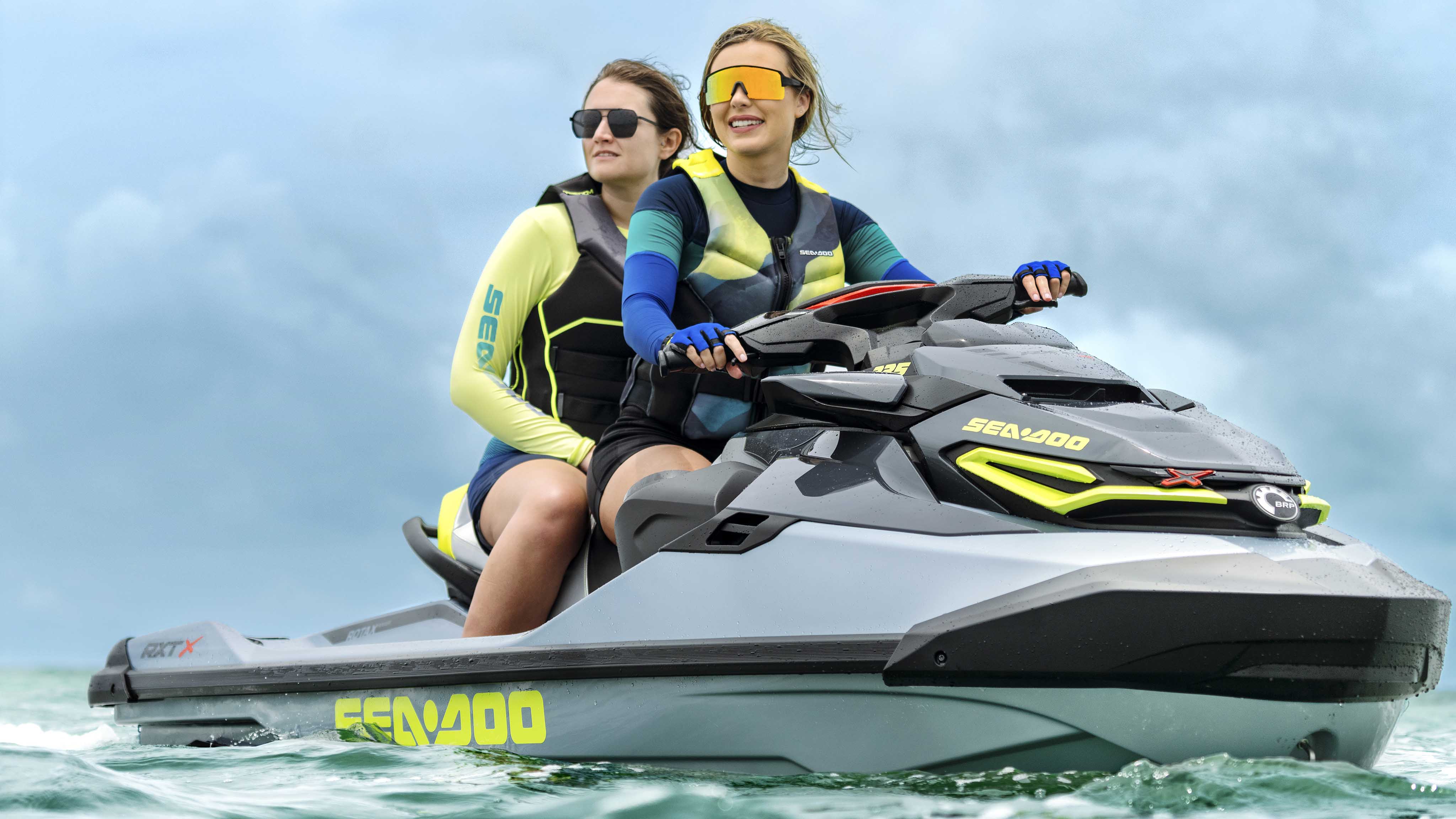 两个朋友坐在闲停的 2024 Sea-Doo 全能艇 RXT-X 上
