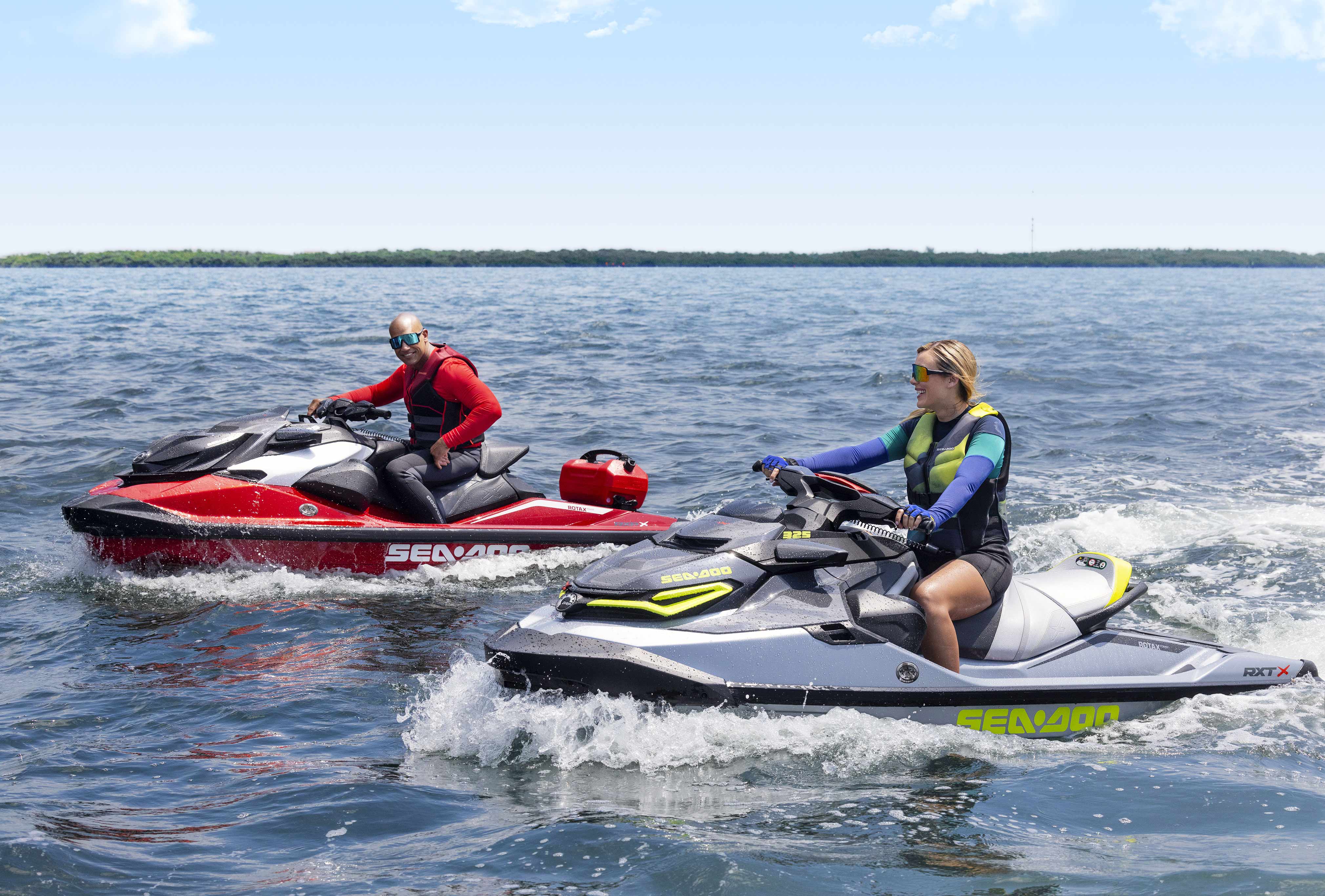 Two Sea-Doo personal watercrafts riding next to one another