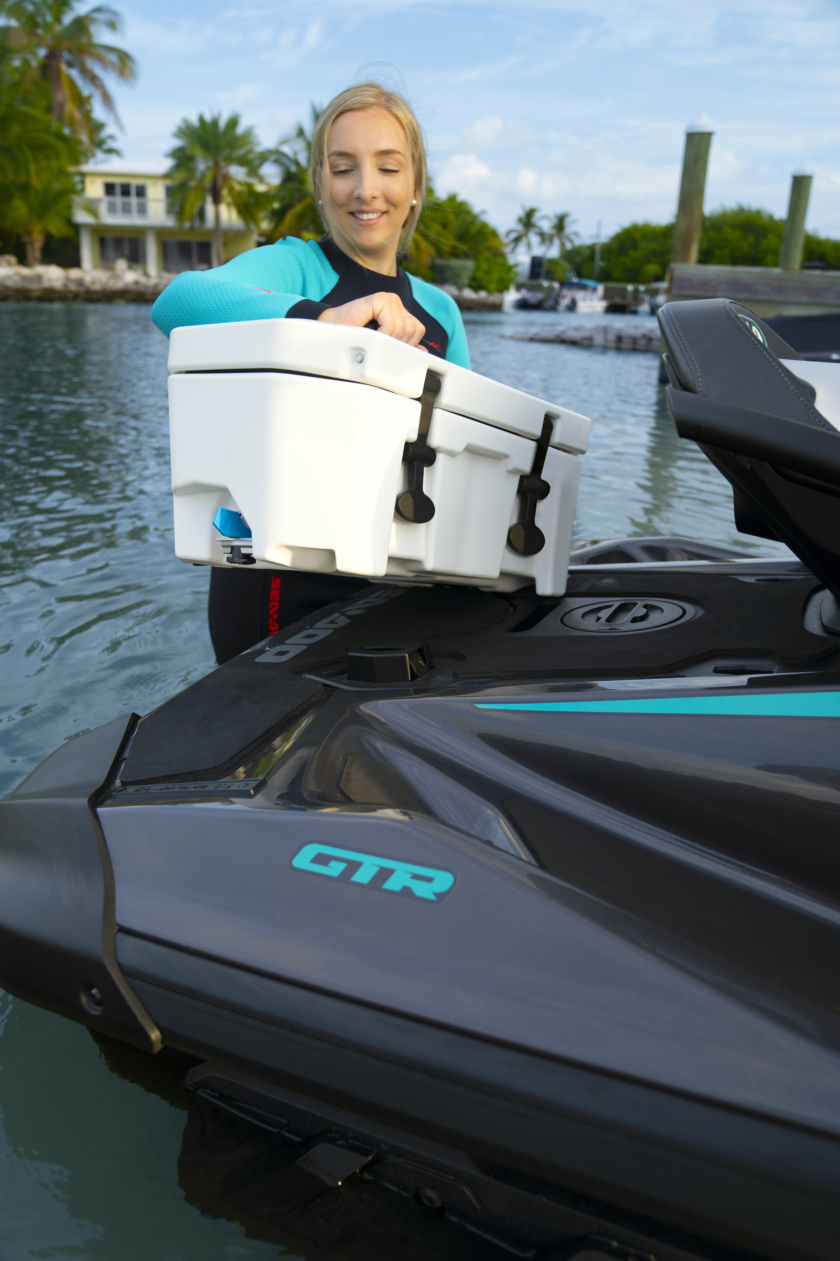 Woman setting us a LinQ cooler on a 2024 Sea-Doo GTR 230 personal watercraft
