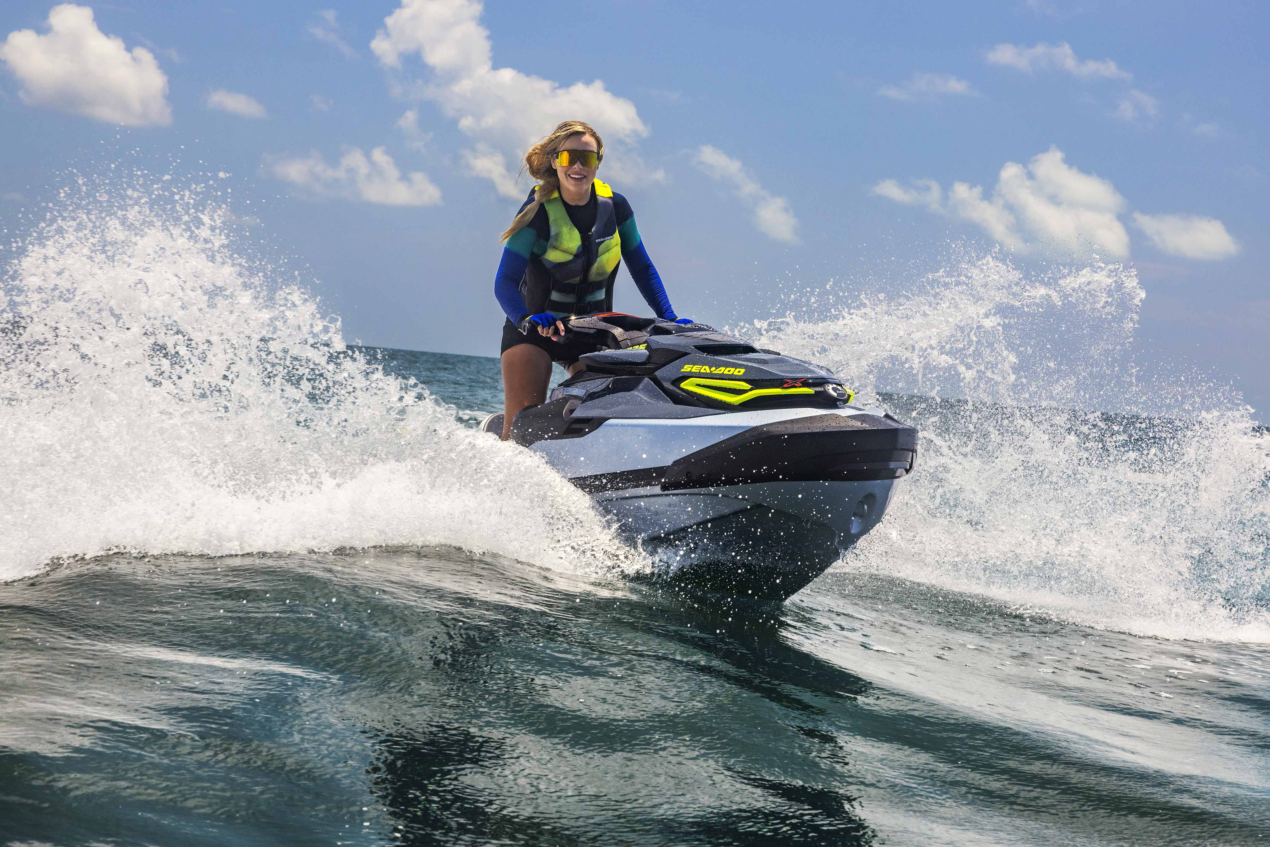 Woman riding a Sea-Doo RXT-X personal watercraft at high speed
