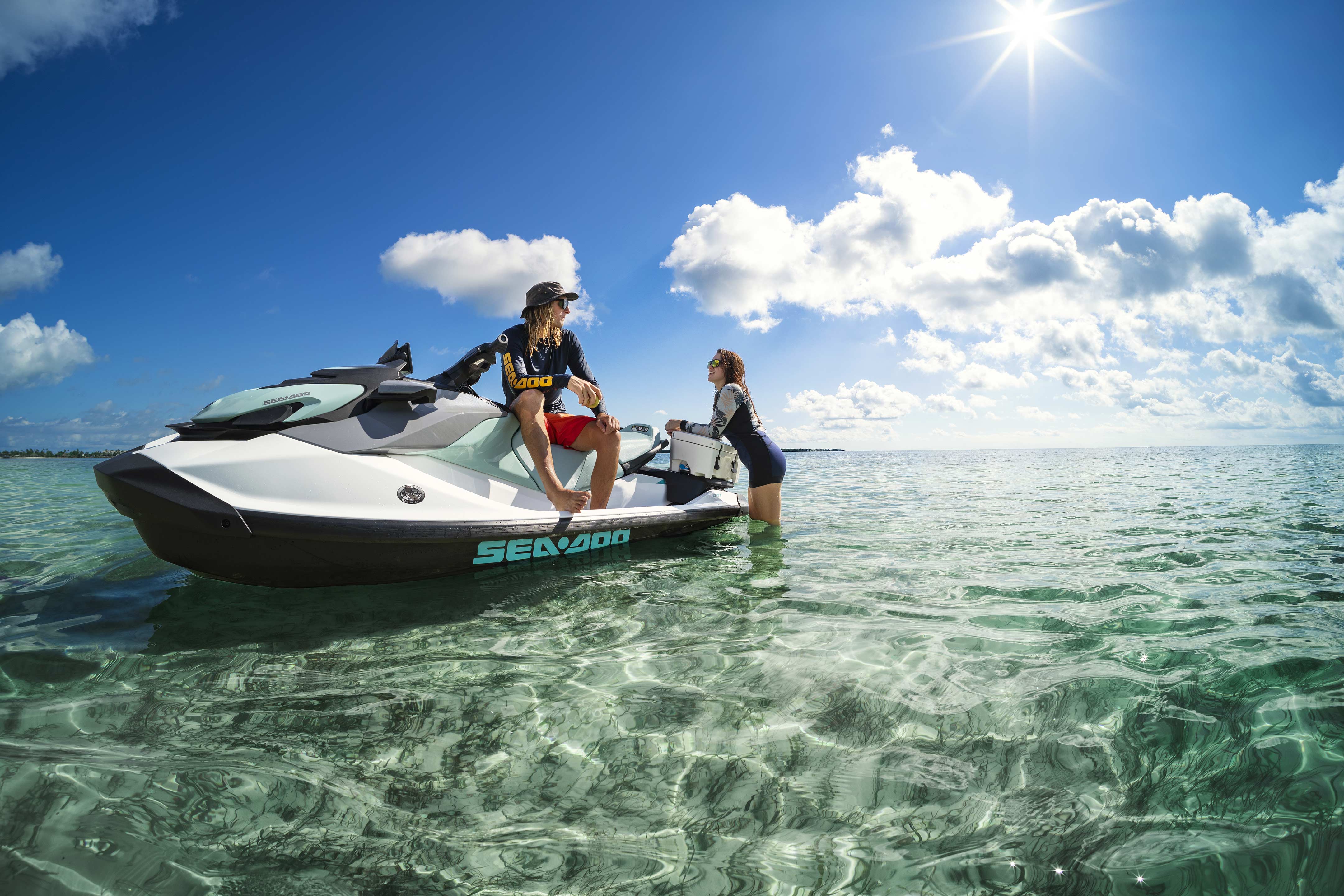 A man and woman talking on an idle recreational Sea-Doo GTI