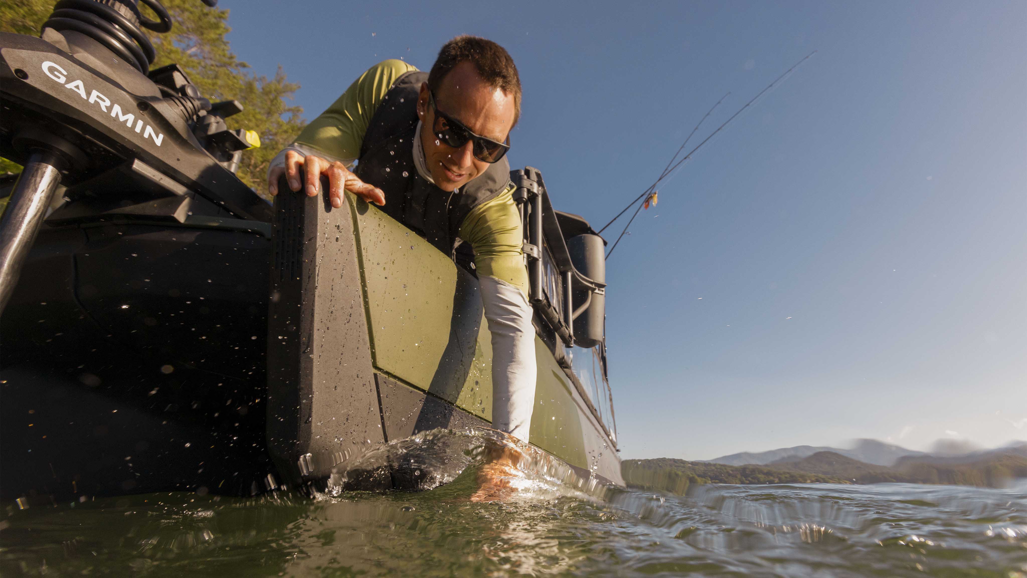 Fisherman grabbing a fish from his 2025 Sea-Doo Switch Fish pontoon