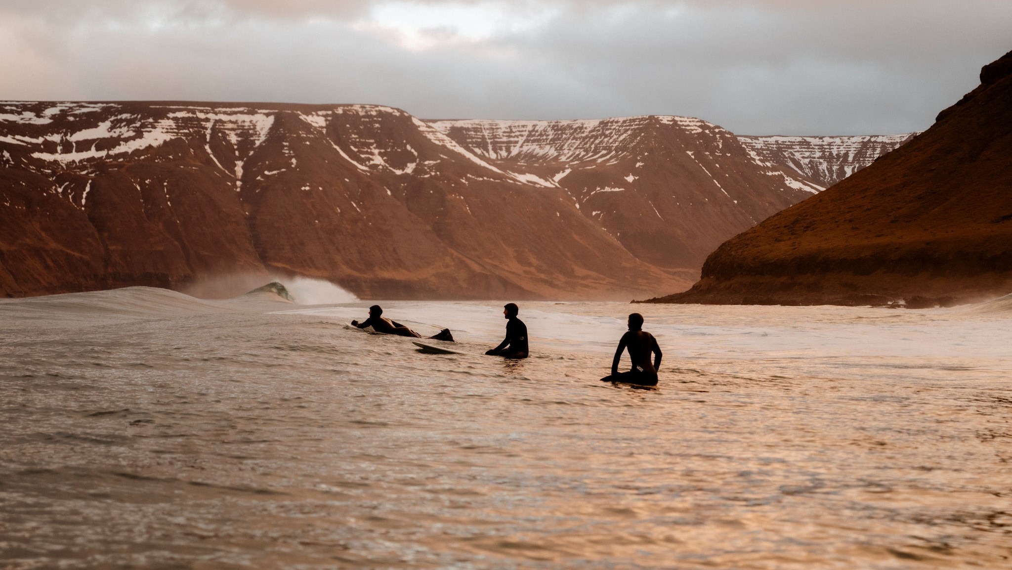 Plusieurs surfeurs dans les eaux islandaises
