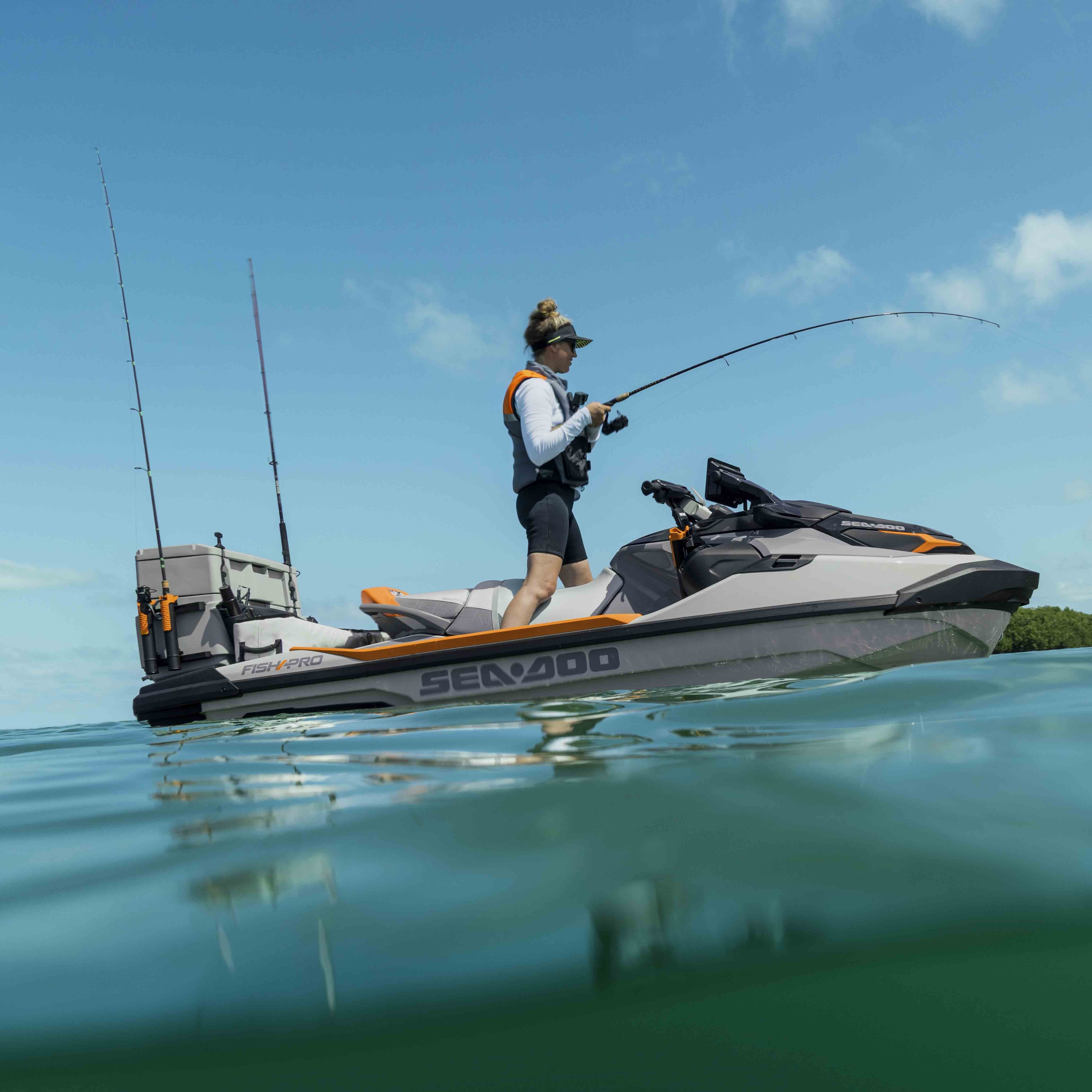 A woman standing on her Sea-Doo FishPro Trophy personal watercraft while fishing