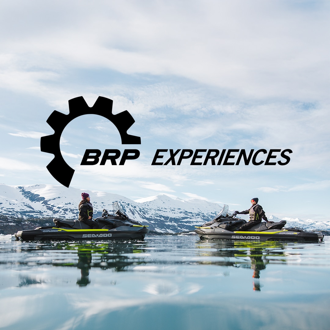 Two women on Sea-Doo Explorer Pro enjoying a BRP Experiences outing in front of snow-capped mountains
