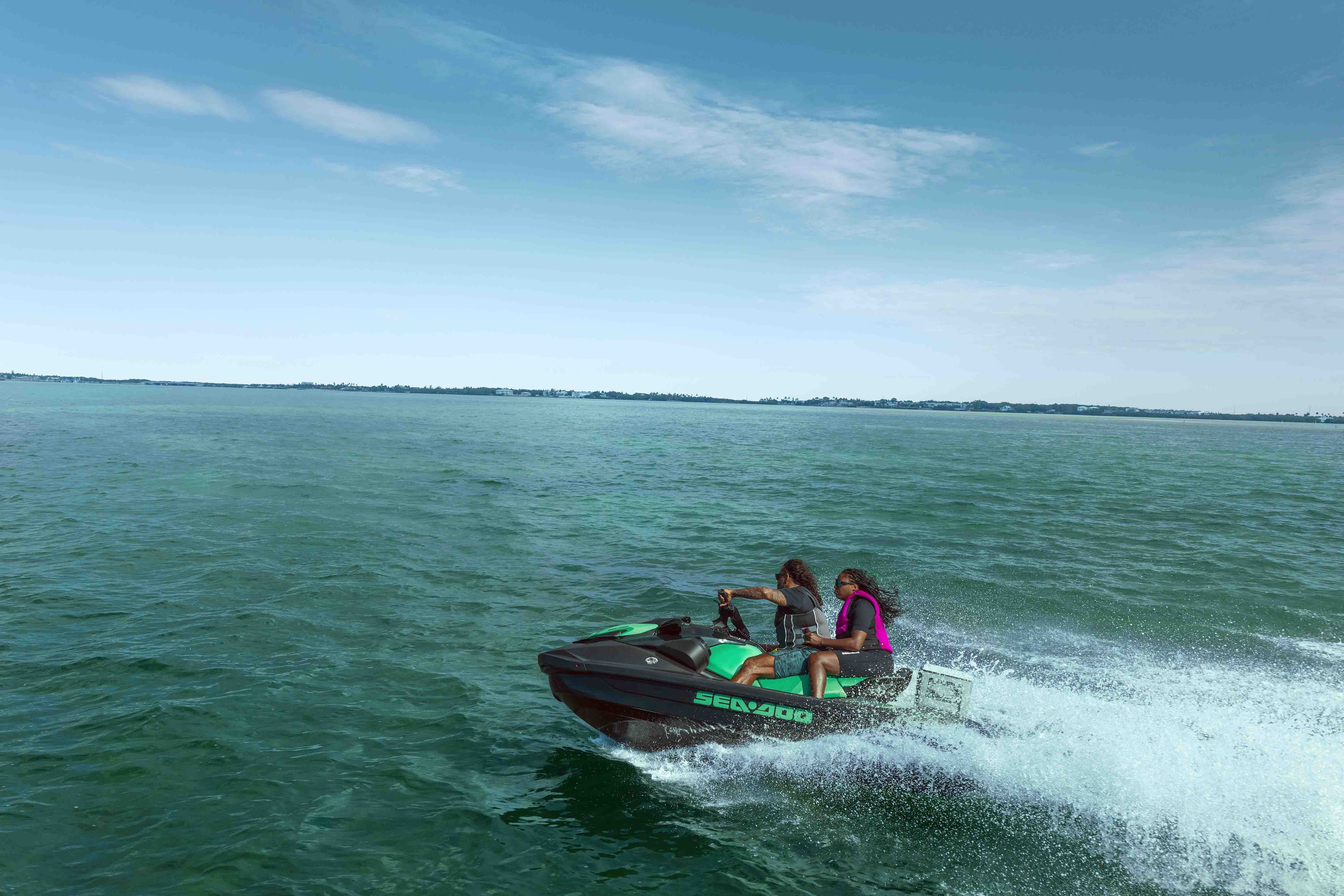 Two women talking on an idle recreational Sea-Doo GTI