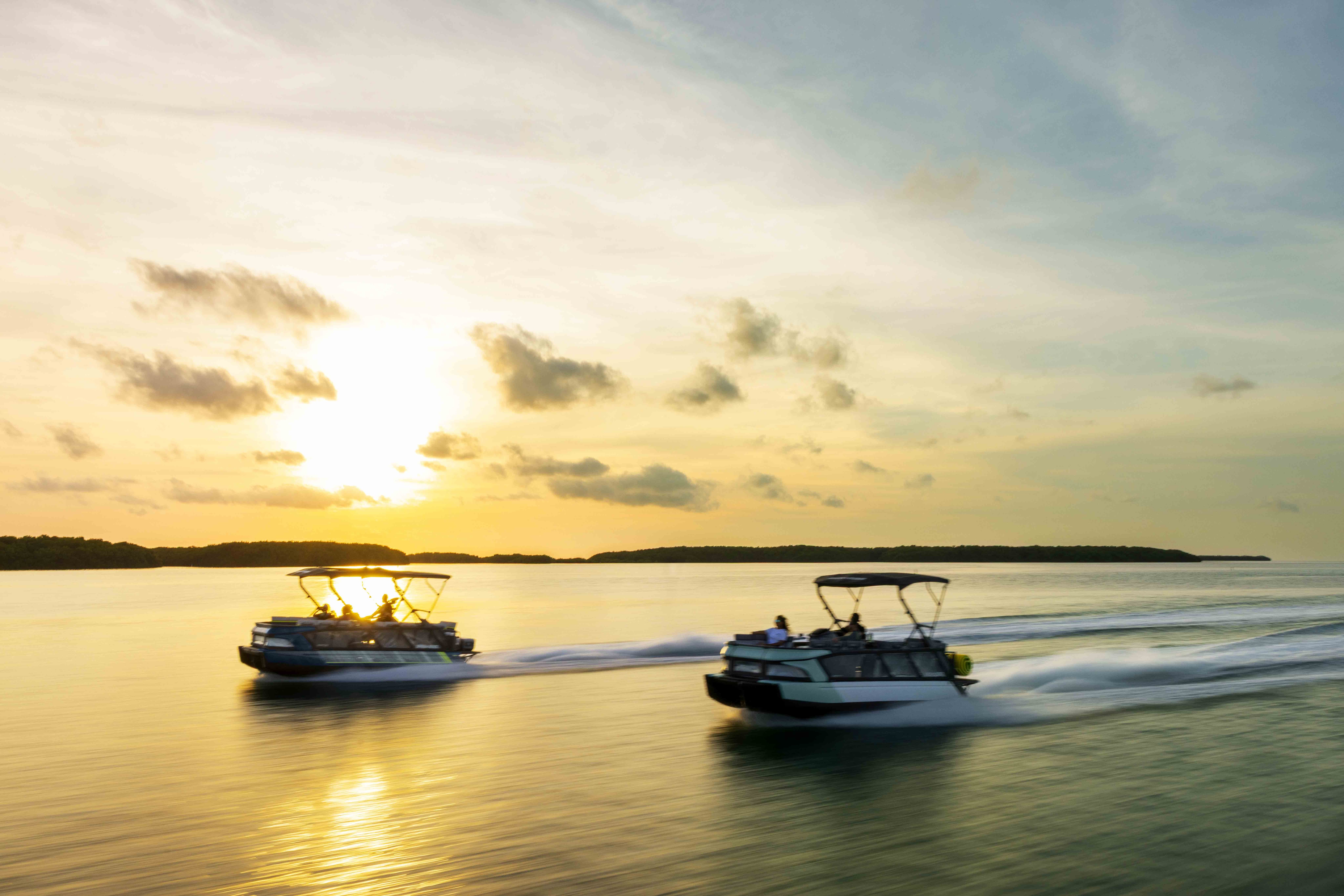 Two Sea-Doo Switch pontoons going at high speed on a lake