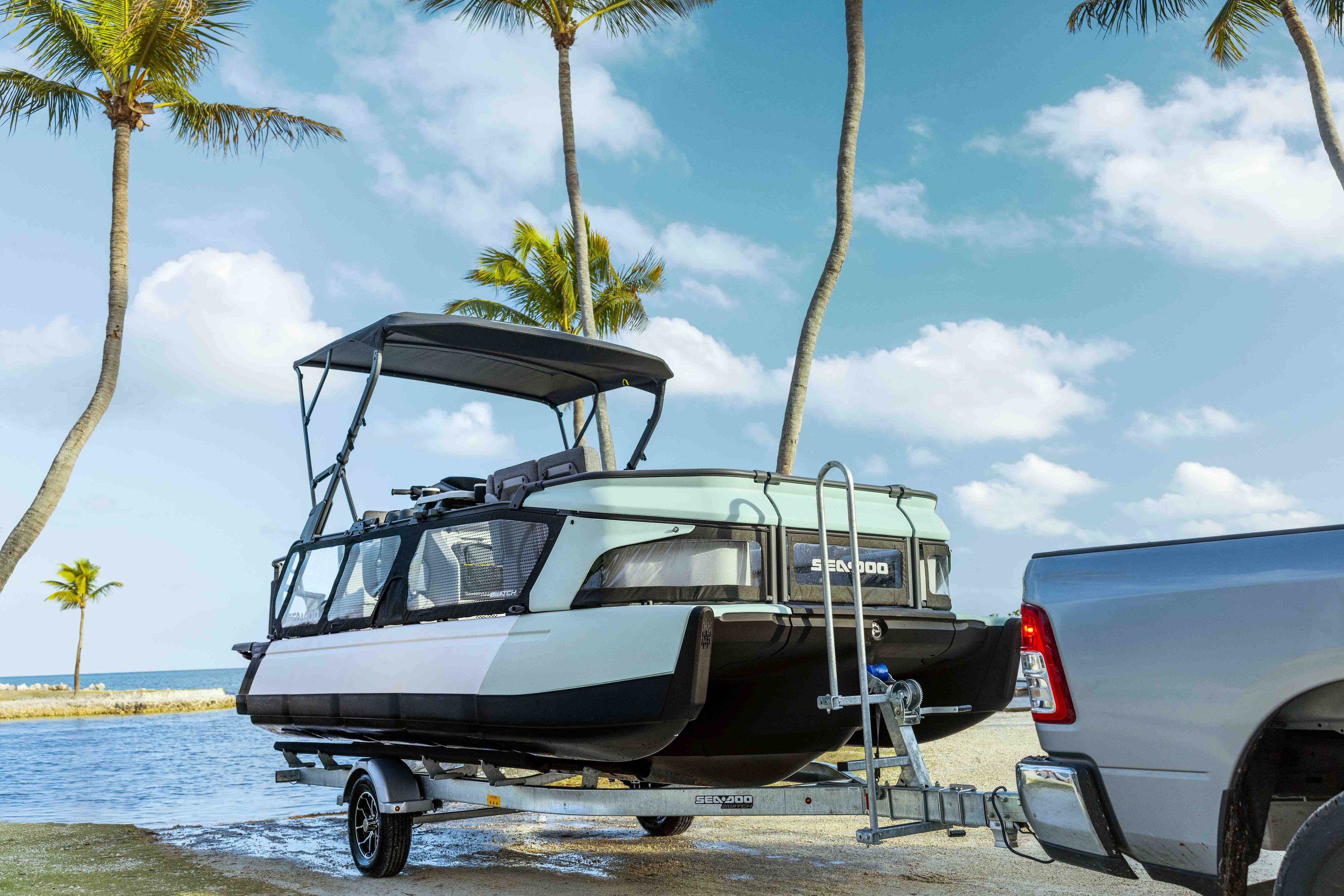A 2026 Sea-Doo Switch Cruise pontoon boat emerging from the water on a trailer