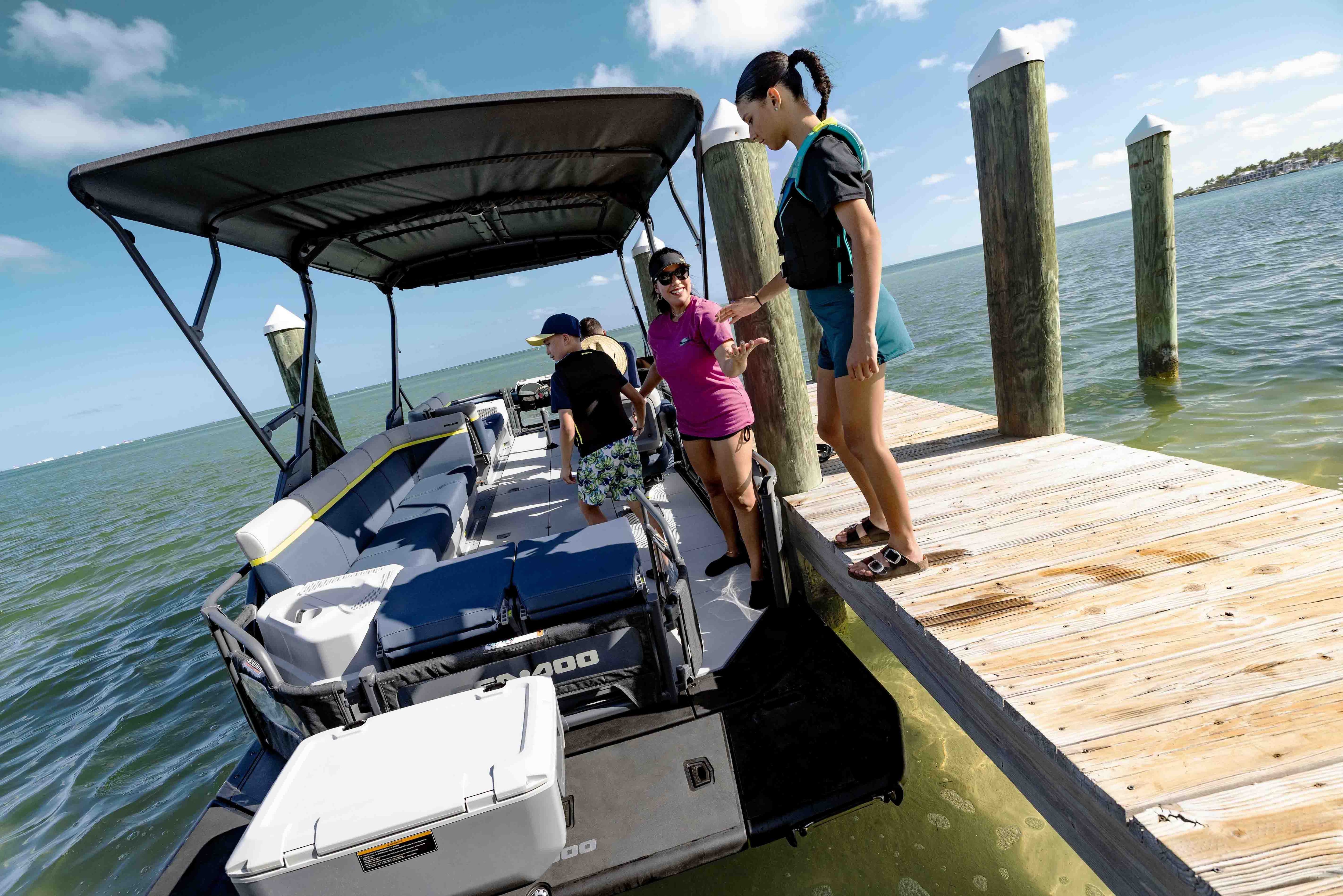 Women boarding a 2026 Sea-Doo Switch Cruise Limited pontoon boat