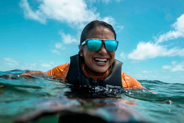 Une femme souriante dans l’eau portant l’équipement complet Sea‑Doo