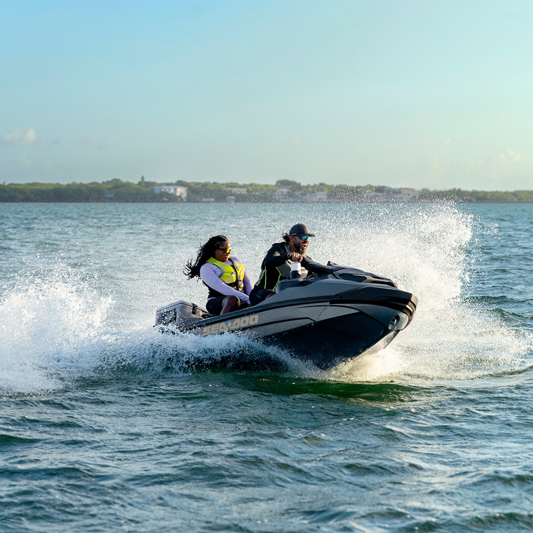A couple riding on a 2027 Sea-Doo GTX Limited personal watercraft