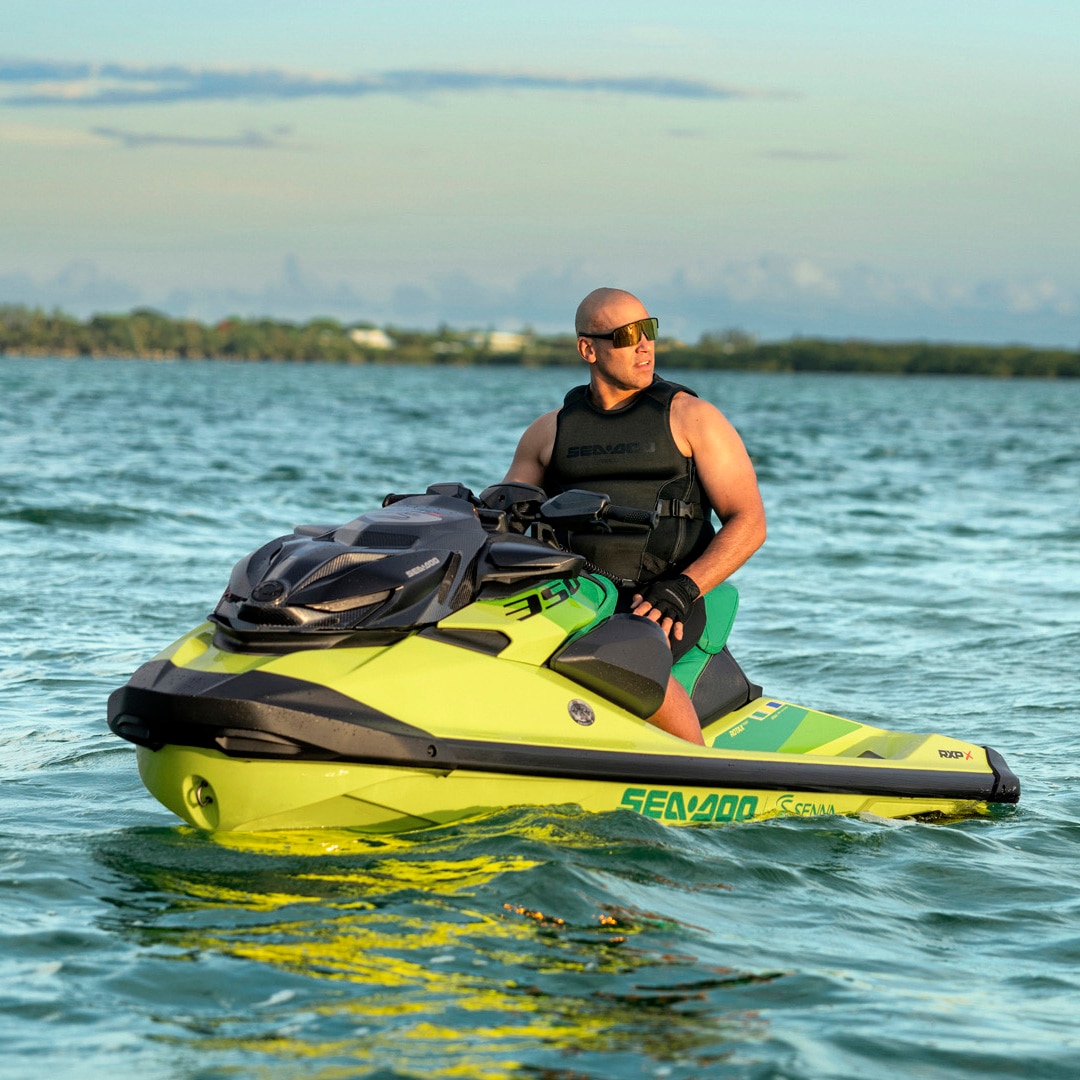 A man on the exclusive 2027 Sea-Doo RXP-X Senna personal watercraft, cruising calmly