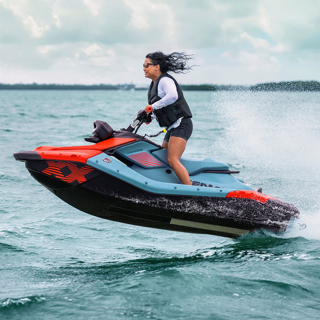 A woman riding a 2027 Sea-Doo Spark X Trixx with 110 hp on a lake