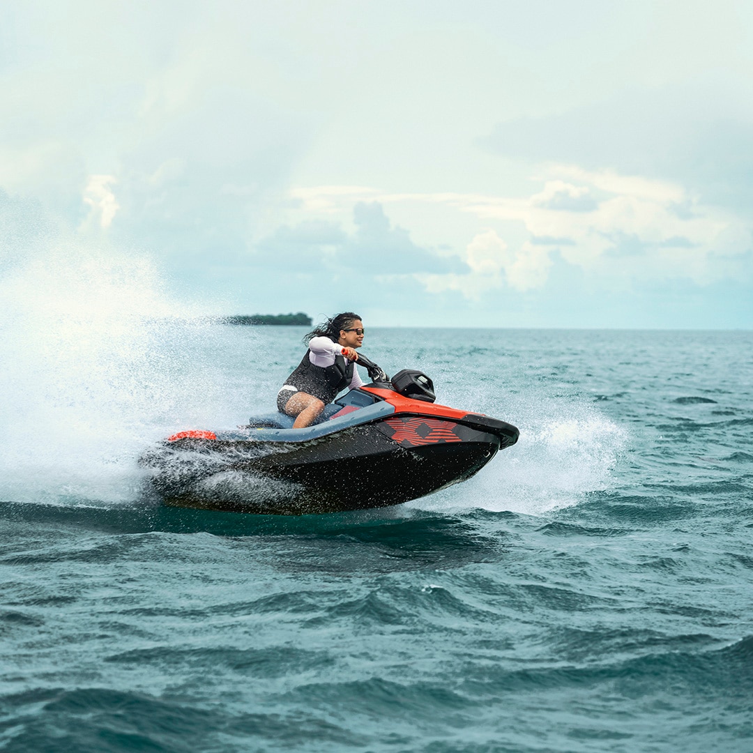 A woman riding a 2027 Sea-Doo Spark X Trixx with 110 hp on a lake 