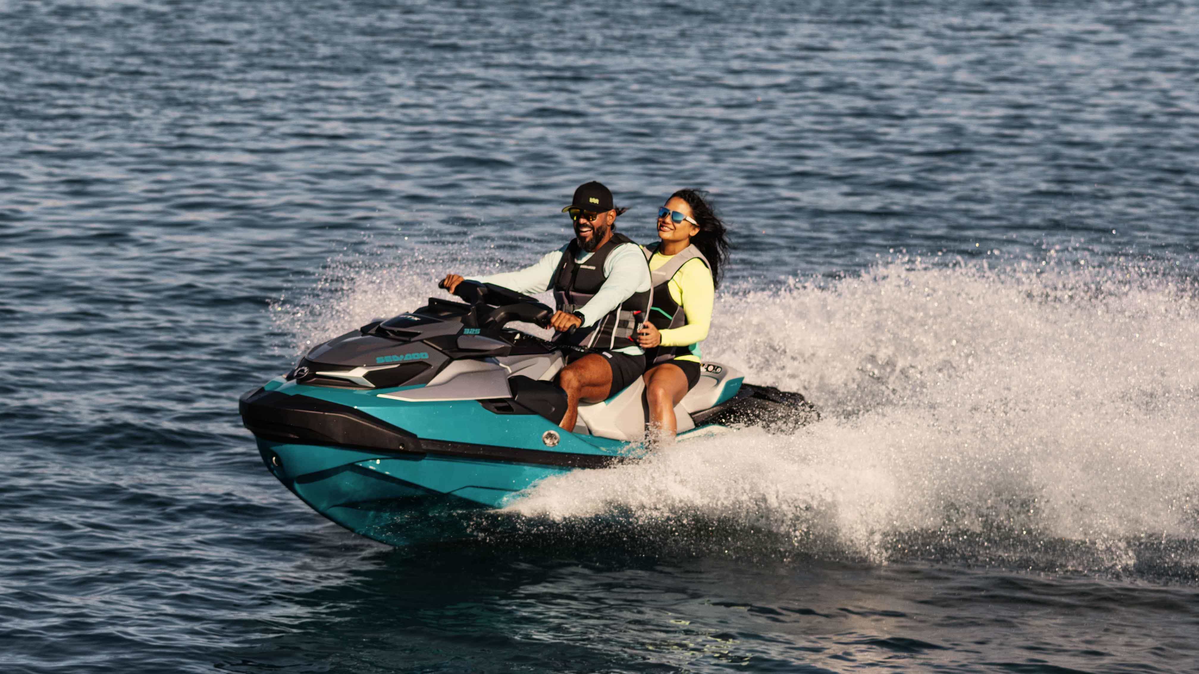 Pareja disfrutando mientras conducen por el mar en una Sea-Doo