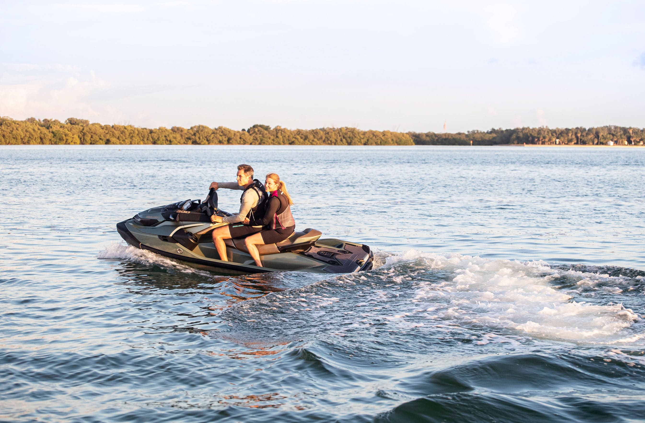 Pareja disfrutando del atardecer sobre su Sea-Doo en el mar 