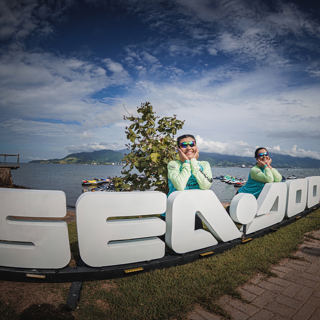 Duas mulheres posando para a foto, apoiadas em letreiro Sea-Doo.