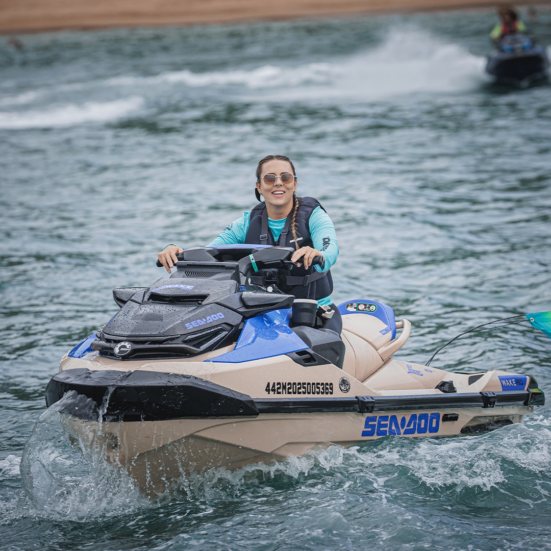 Mulher pilotando moto aquática.
