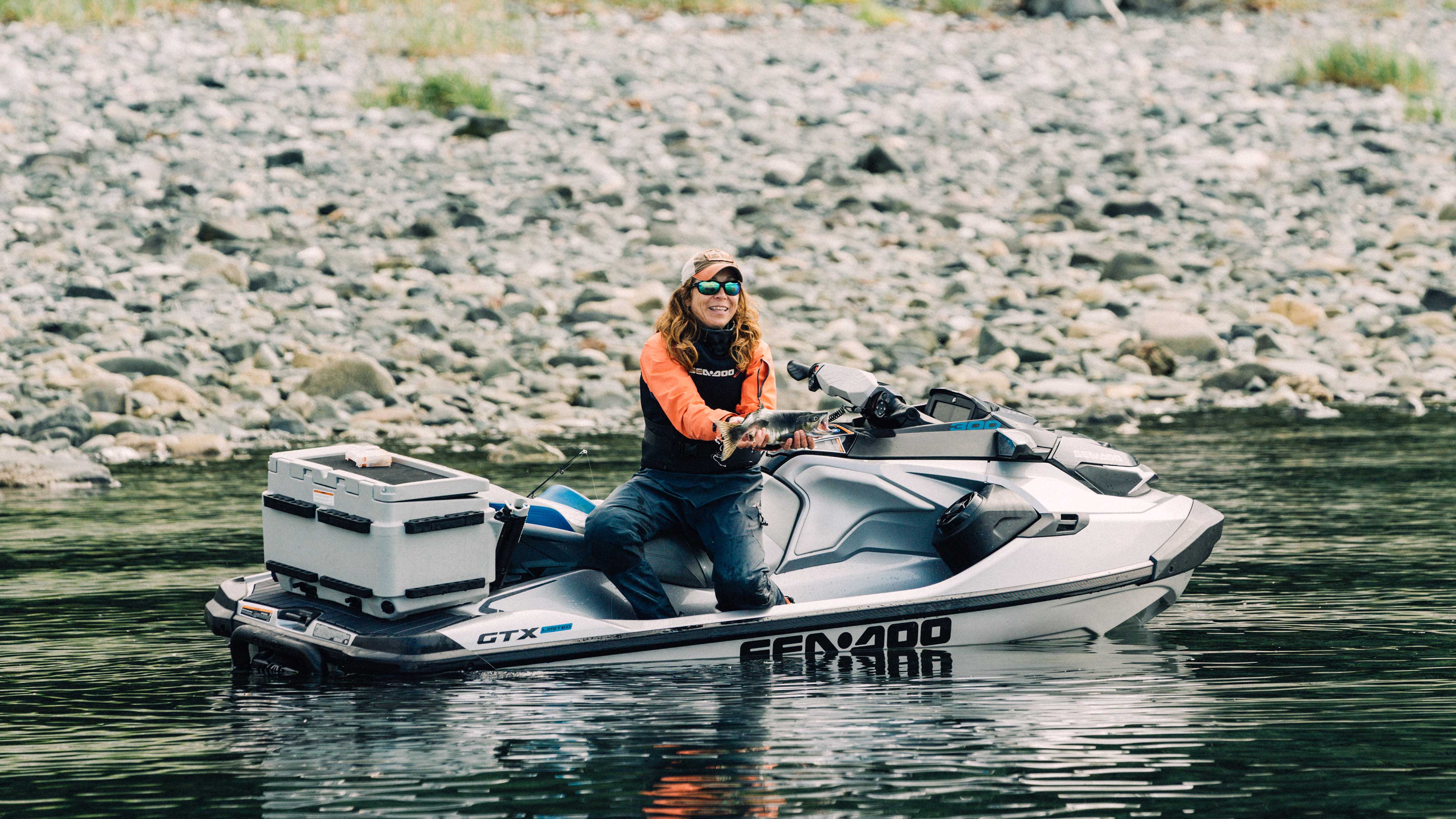 Michelle Oakley fishing and smiling on her Sea-Doo
