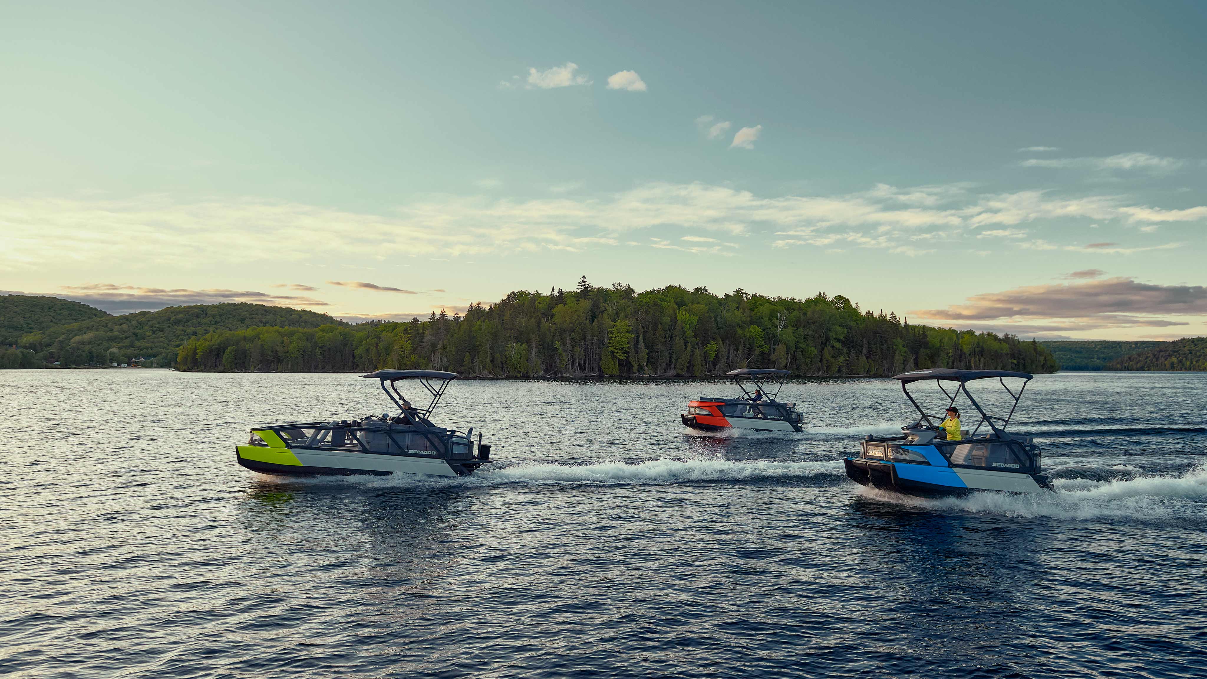 Three Sea-Doo Switch pontoon boats riding on a lake