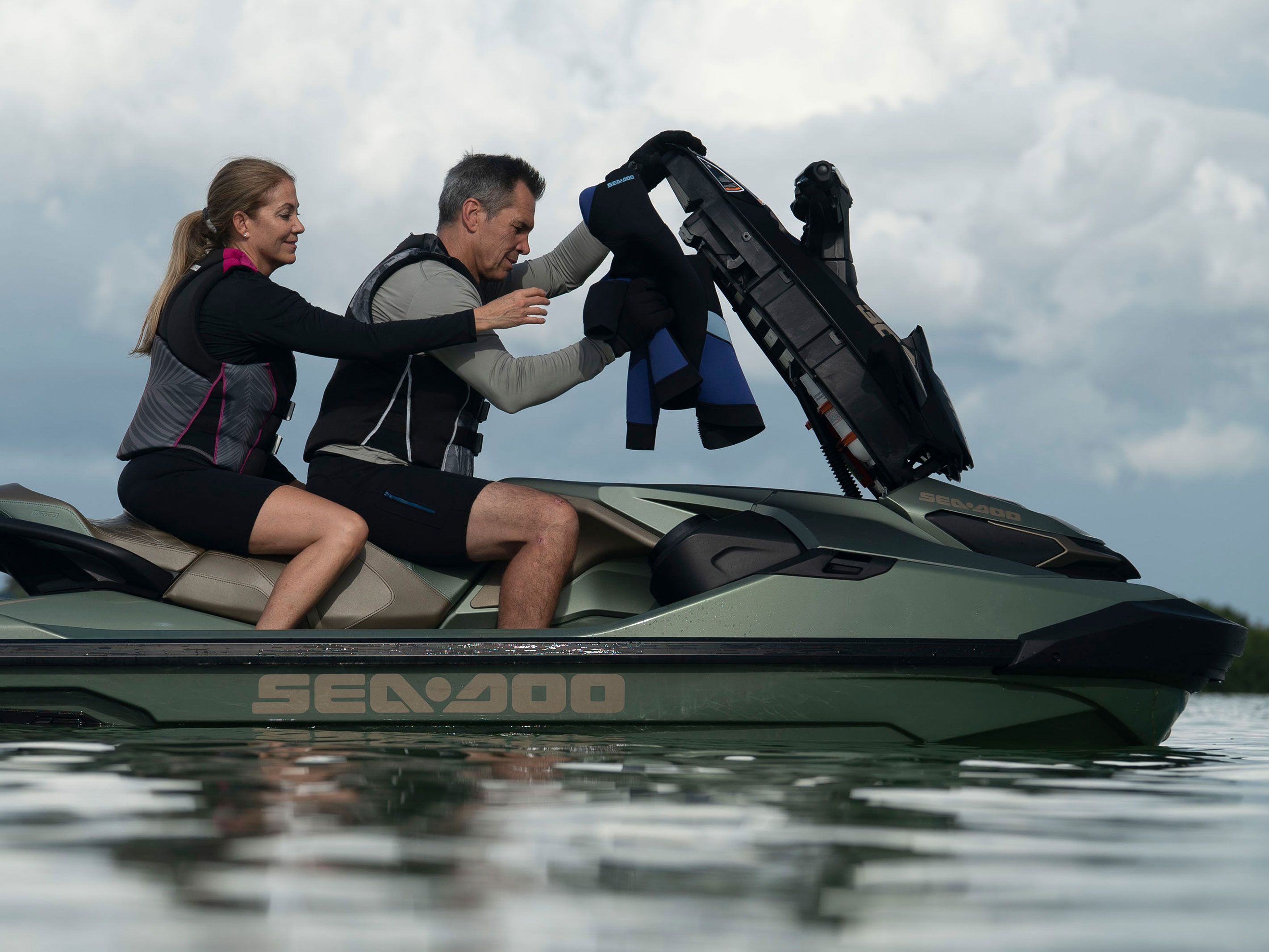 Couple adding items to the direcct access front storage of their Sea-Doo GTX Limited