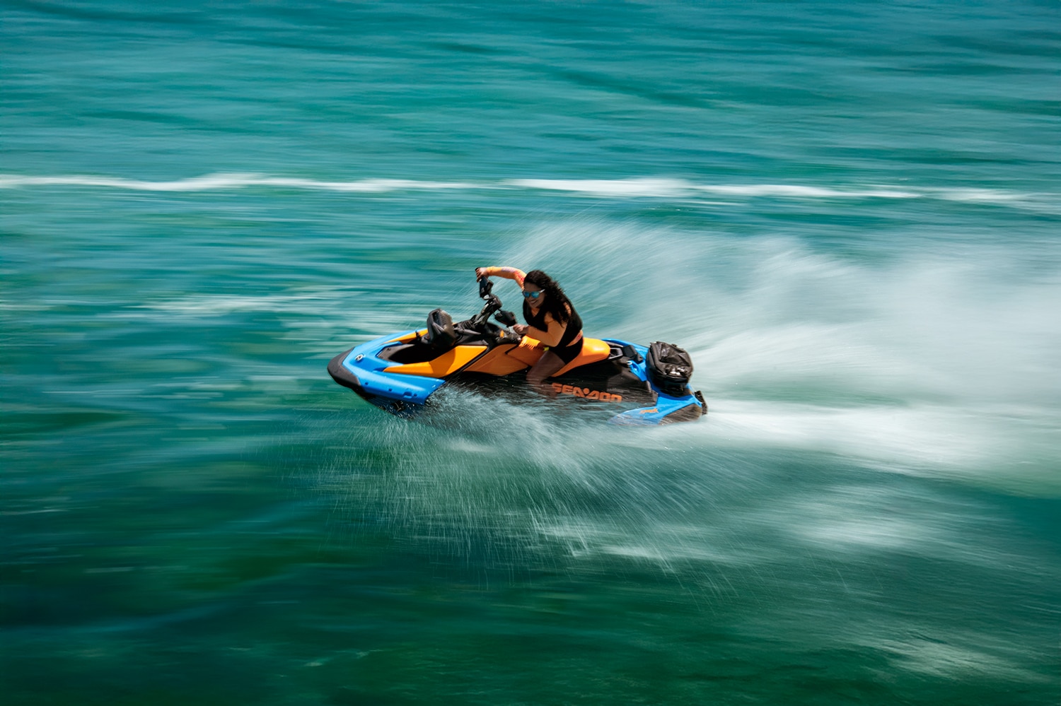 Una mujer realizando acrobacias en su moto acuática Sea-Doo Spark 2026.