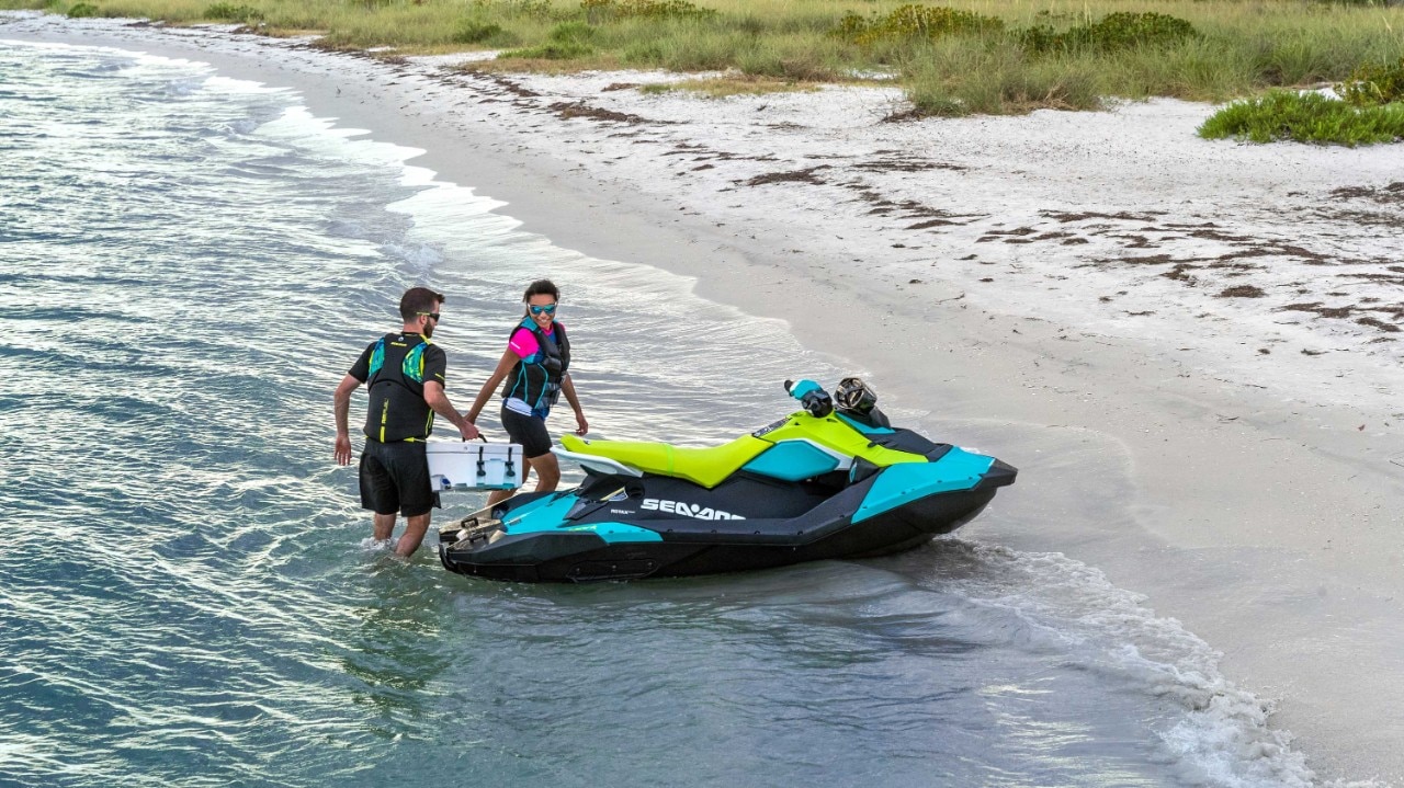 Pareja llegando a la playa con su Sea-Doo